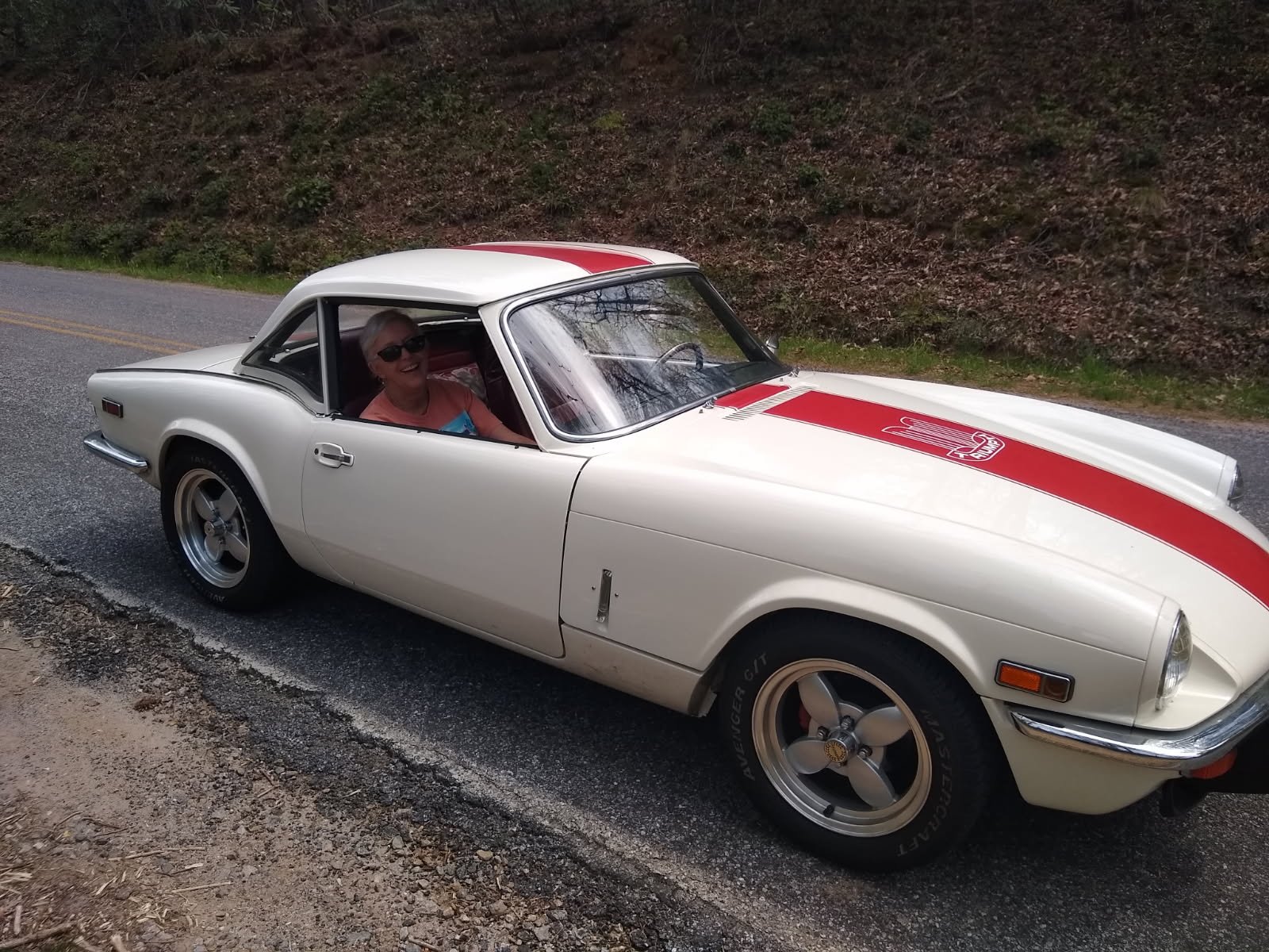 Sonja Thompson driving the 1972 Triumph Spitfire Mk IV on a mountain road